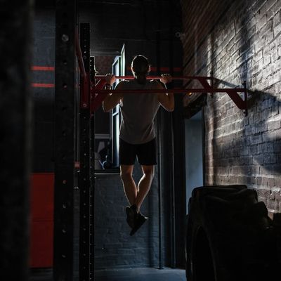 Close-up of hands gripping a pull-up bar with focused determination.