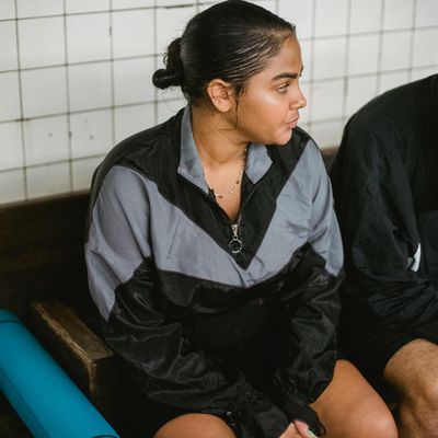 Man sitting in a calm, reflective pose after a workout session.